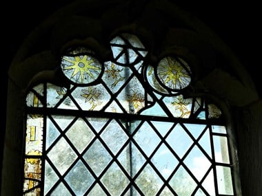 A close-up image showing a sanctuary window with stained glass planes.