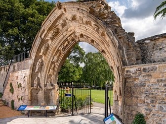 A section of an incomplete ruin wall with an archway in the centre. 