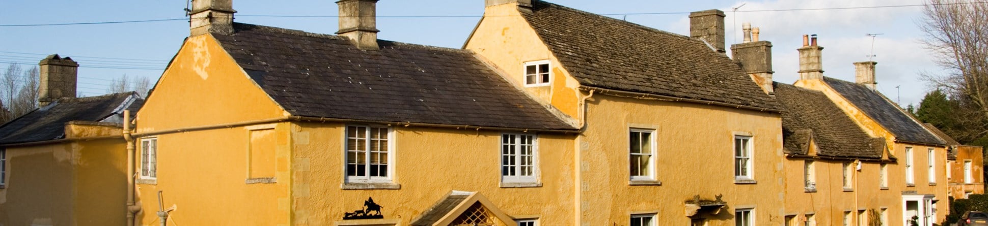 High Street, Badminton, Gloucestershire.  General view of cottages with uniform limewash.