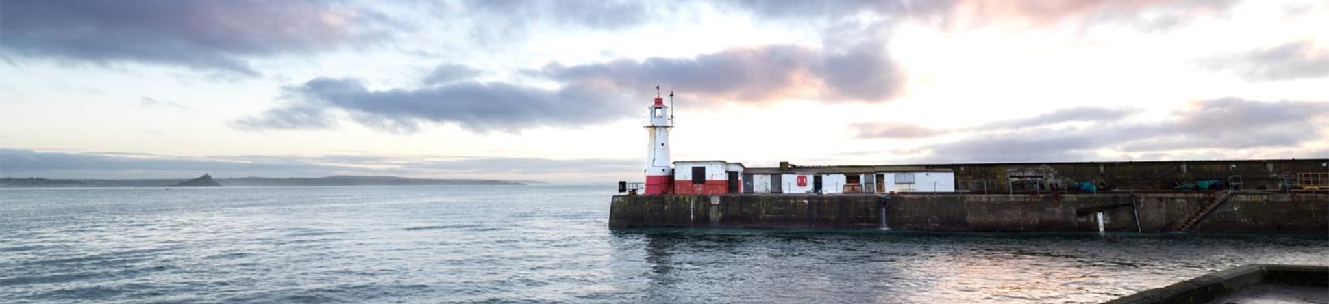 Lighthouse at the end of a pier surrounded by water