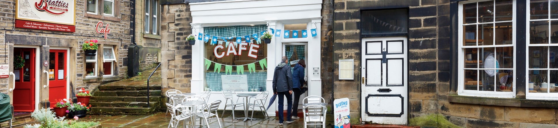 The exterior of a cafe in the rain. 