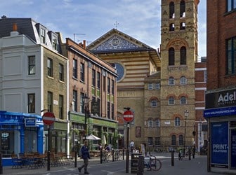 View of a Church appearing behind shop fronts. 